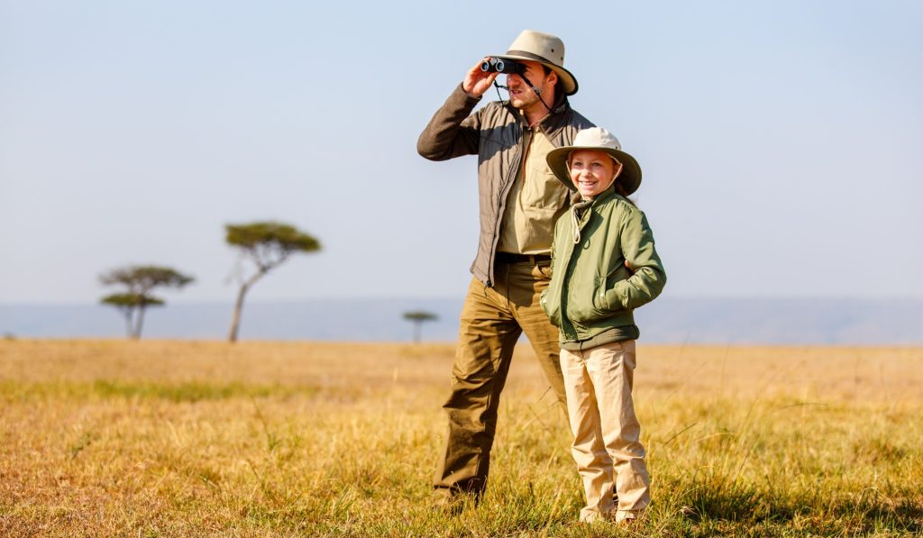 Quels animaux sauvages sont présents en Ouganda ? Un homme et un enfant observe la faune avec des jumelles