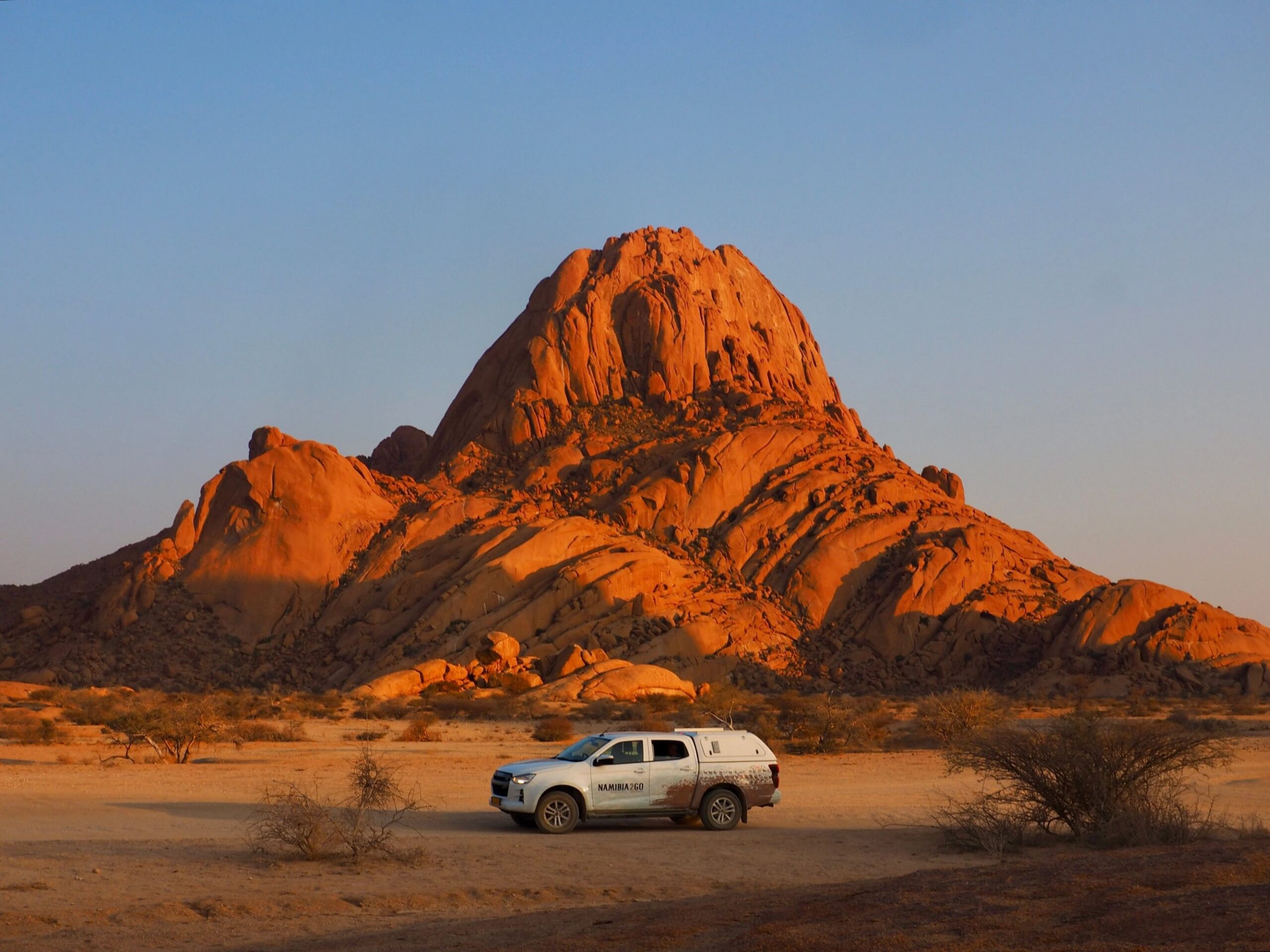 Safari vehicle parked below Spitzkoppe